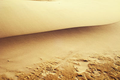 High angle view of footprints on sand at beach