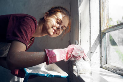 Side view of young woman sitting at home