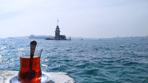 Bell tower by sea against sky with the turkish tea