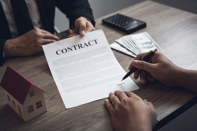 High angle view of people with text on paper at table