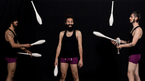 Young couple standing against black background