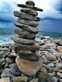 Stack of stones on beach against sky