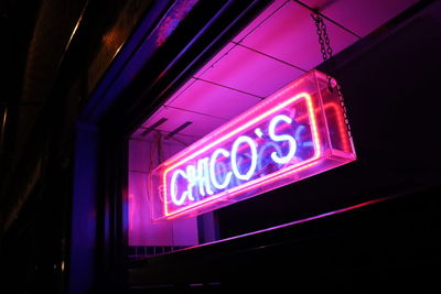 Low angle view of illuminated sign at night