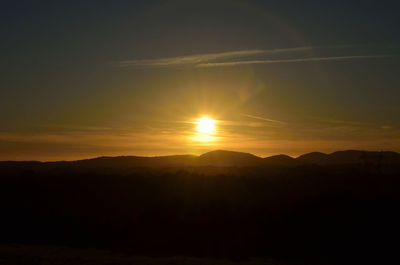 Scenic view of silhouette mountains against romantic sky at sunset