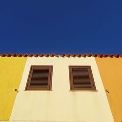 Low angle view of building against clear blue sky