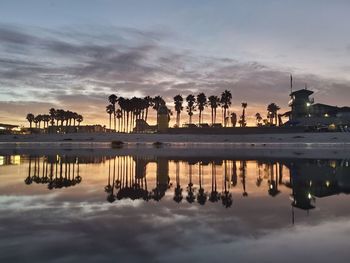 Reflection of buildings in ocean at sunset