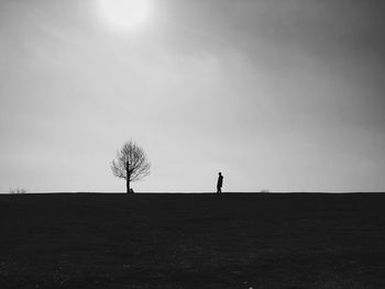 Silhouette person on field against clear sky