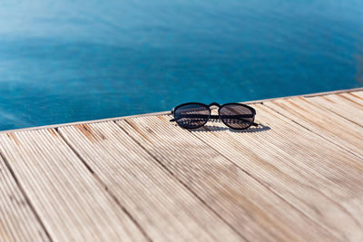Close-up of sunglasses on chair at swimming pool
