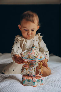 Portrait of cute girl playing with toy on bed