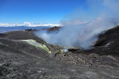 Smoke emitting from volcanic mountain against sky