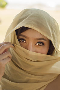 Portrait of a beautiful young woman covering face