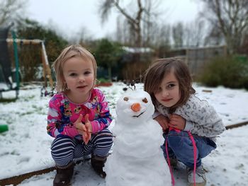 Portrait of cute girl making snow during winter outdoors