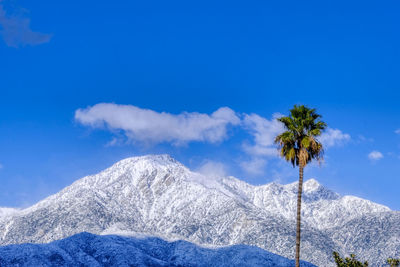 Scenic view of snowcapped mountains against blue sky