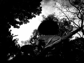 Low angle view of silhouette trees against sky