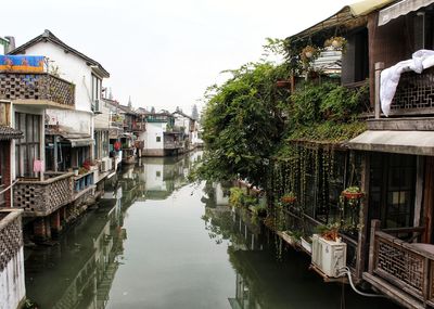 Canal amidst buildings against sky