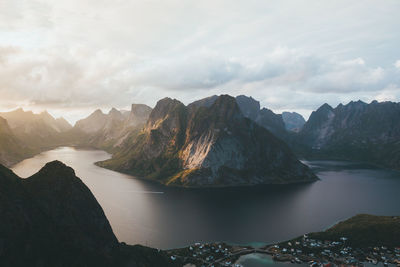 Scenic view of lake and mountains against cloudy sky