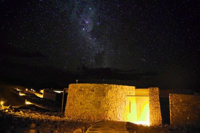 Illuminated building against sky at night
