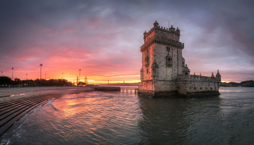 Tower bridge over river against sky during sunset