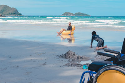 People on beach against sky