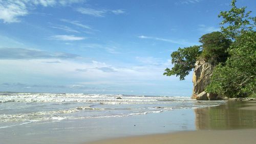 View of calm beach against blue sky