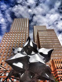 Low angle view of modern building against cloudy sky