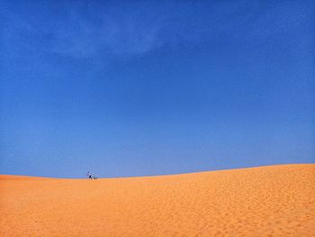 Scenic view of desert against clear blue sky