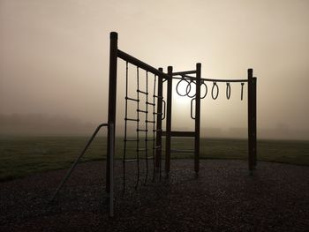 Metallic structure on land against sky during sunset