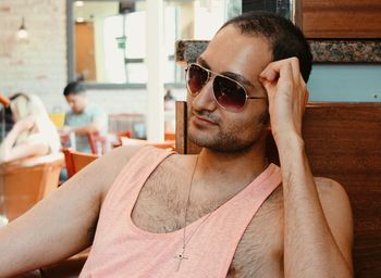 Close-up of young man wearing sunglasses while sitting in cafe