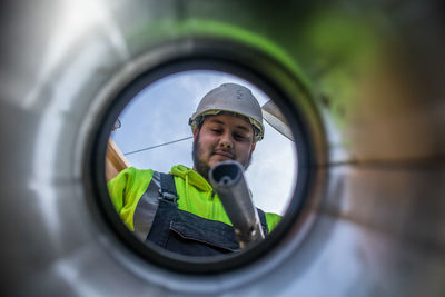 Low angle view of young man seen through window