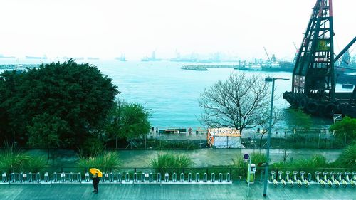 People by sea against sky in city