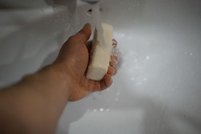 Close-up of person hand holding wet glass at home