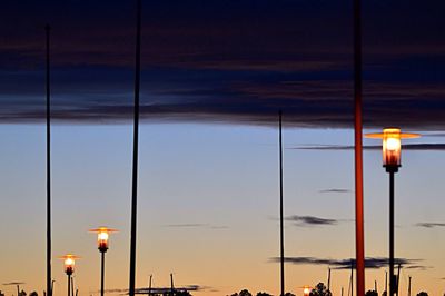 Illuminated street light against sky at sunset