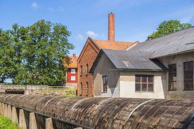 Old house by building against sky
