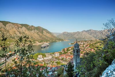 Scenic view of lake and mountains against clear blue sky