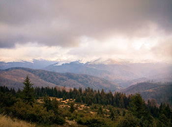 Scenic view of mountains against cloudy sky