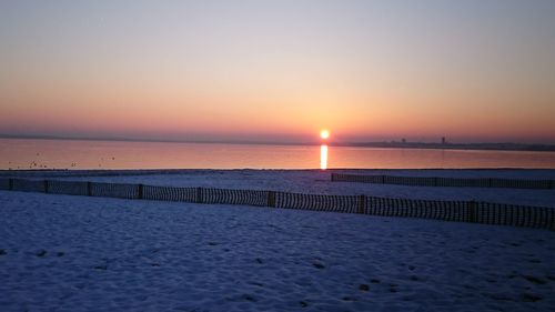 Scenic view of sea against clear sky during sunset