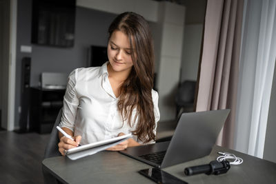 Young woman using laptop at home