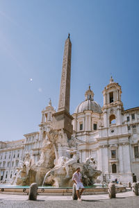 Man standing against statue of historic building