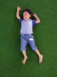 High angle view of boy lying on grass