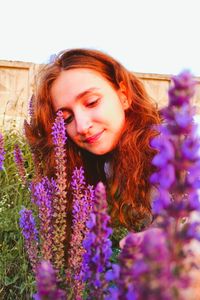 Portrait of beautiful young woman with purple flower