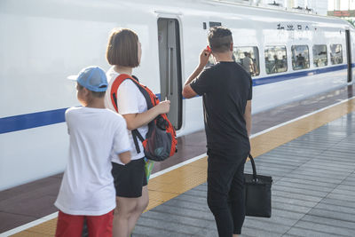 Rear view of people standing at airport