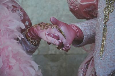 Midsection of couple holding hands during wedding ceremony