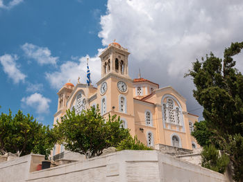 Low angle view of trees and building against sky