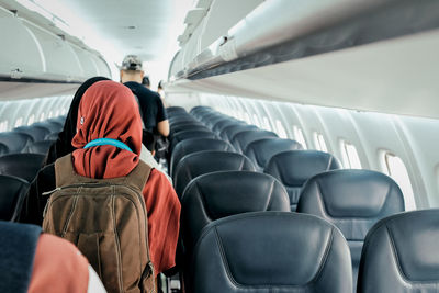 Rear view of man standing in airplane