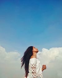 Low angle view of woman standing against sky