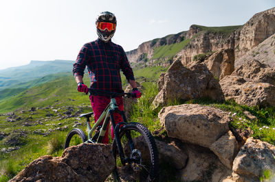 Rear view of man riding bicycle on mountain