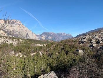 Scenic view of landscape and mountains against clear blue sky