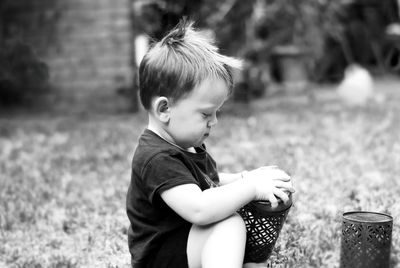 Side view of boy holding container on field
