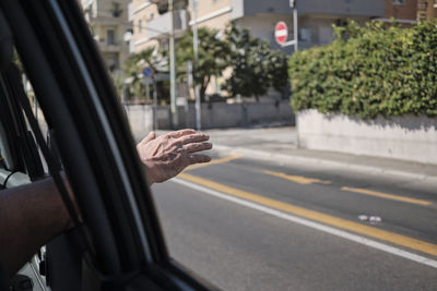 Cropped image of man in car on road