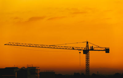 Cranes at construction site during sunset